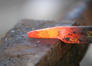 The hot iron burns initials and leaves a lasting scar.
