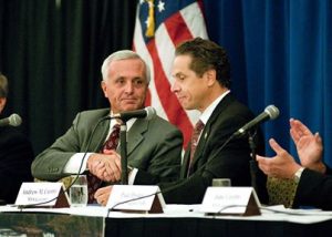 Hamister and Cuomo shake hands on the dubiously financed Hamister Hotel.