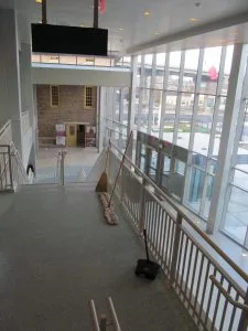 The brooms and dustpan neatly arrayed at the top of the stairs. Must be break time.